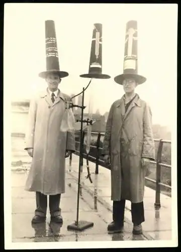 Fotografie unbekannter Fotograf und Ort, zwei Wissenschaftler mit Versuchsaufbau und Pylonen auf dem Kopf