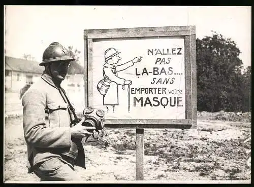 Fotografie französischer Soldat mit Stahlhelm und deutscher Gasmaske in der Hand, Warnschild zum tragen der Gasmaske