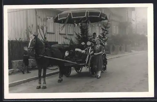 Foto-AK Paar mit tannengeschmückter Pferdekutsche auf einer Strasse
