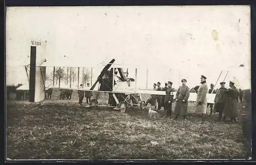 Foto-AK Doppeldecker-Flugzeug, drumherum Soldaten in Uniform
