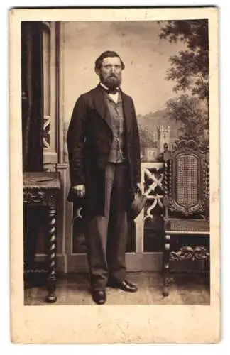 Fotografie C. Eulenstein, Leipzig, Portrait stattlicher Herr mit Vollbart im Anzug hält Schirmmütze in der Hand