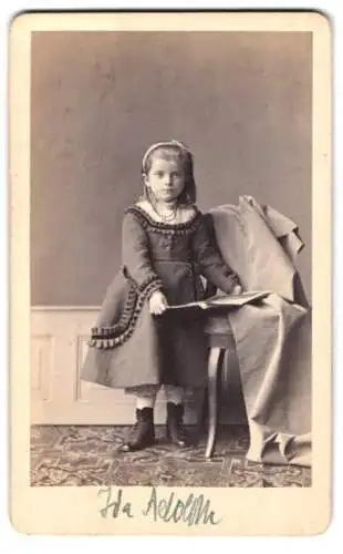 Fotografie Felix Heinze, Dresden, Pillnitzer Str. 34b, Mädchen mit Haarreif und Halskette hält Fotoalbum in den Händen