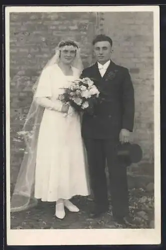 Foto-AK Neu verheiratetes Brautpaar vor einer Hauswand