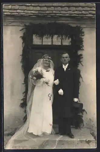 Foto-AK Braut und Bräutigam vor einer geschmückten Haustür