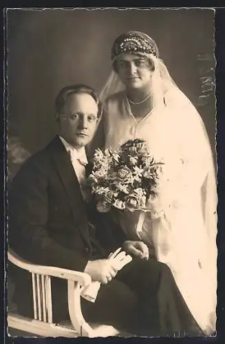 Foto-AK Sitzender Bräutigam und stehende Braut