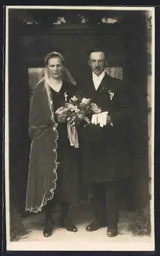 Foto-AK Brautpaar in dunkler Kleidung vor seiner Haustür