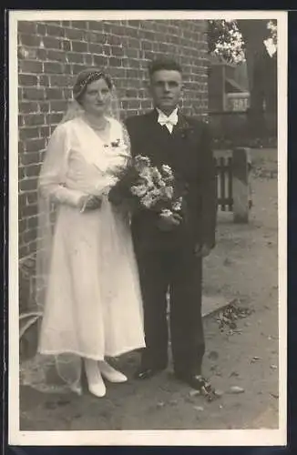 Foto-AK Junges Brautpaar vor einer Hauswand