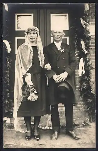 Foto-AK Älteres Brautpaar vor geschmückter Haustür
