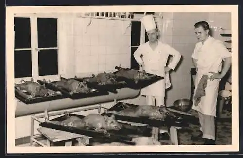 Foto-AK Zwei Köche vor sechs zubereiteten Spanferkeln