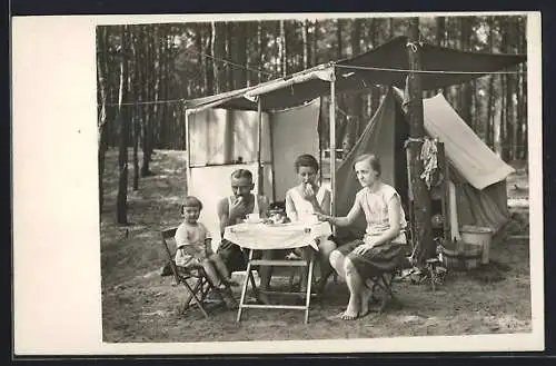 Foto-AK Familie isst an einem Tisch vor ihrem Zelt auf einem Camping-Trip