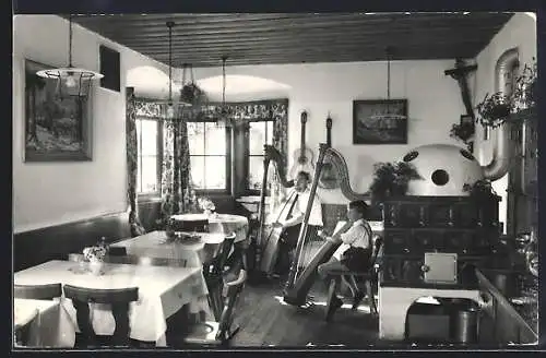 AK Schwaz /Tirol, Alpengasthof Egertboden der Fam. Dessl-Stöckl, Innenansicht mit Mann und Kind an der Harfe