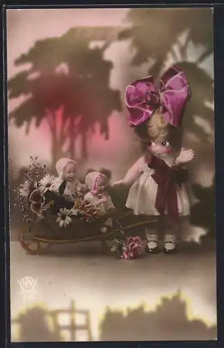 AK Puppe mit zwei Puppenkindern in einer Schubkarre
