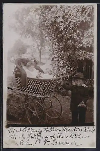 Foto-AK Kleiner Junge mit Kind im Kinderwagen in einer Parkanlage