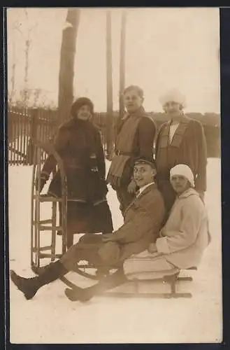 Foto-AK Zwei junge Männer und drei Frauen mit ihren Schlitten