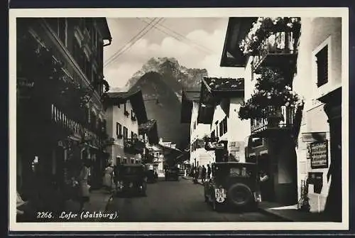 AK Lofer, Strassenleben mit Autos und Geschäften