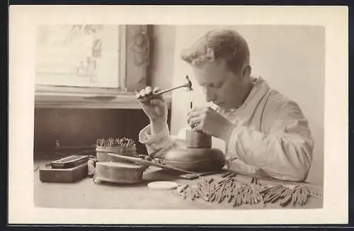 Foto-AK Ein junger Metallhandwerker bei der Arbeit mit Hammer und Meissel