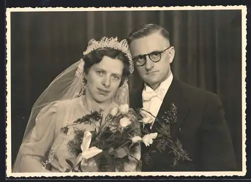 Foto-AK Frisch vermähltes Paar, Braut mit Blumenstrauss, Bräutigam mit Brille