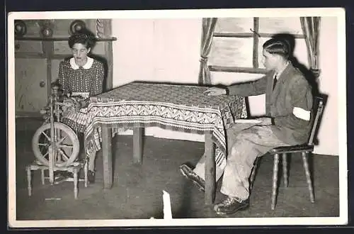 Foto-AK Mann und Frau sitzen an einem Tisch mit Spinnrad