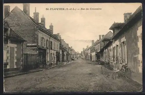 AK St-Flovier, Rue du Commerce animée avec bâtiments et vélos