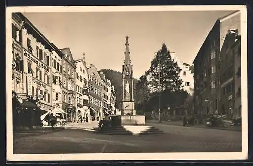 AK Kufstein in Tirol, Unterer Stadtplatz mit Geschäften und Denkmal
