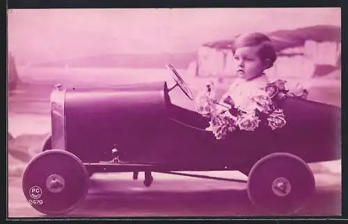 AK Kleiner Junge in einem Spielzeugauto vor Fotokulisse