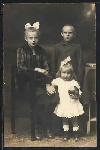 Foto-AK Kleines Mädchen mit Spielball und zwei grösseren Geschwistern