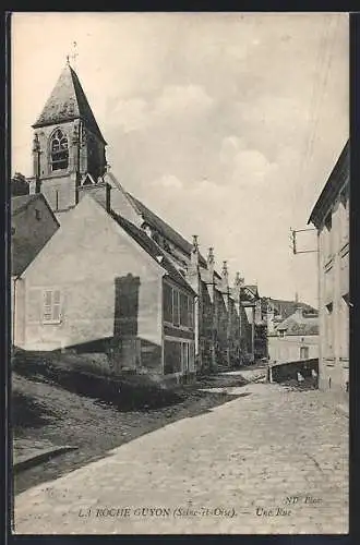 AK La Roche-Guyon, Une rue avec église en arrière-plan