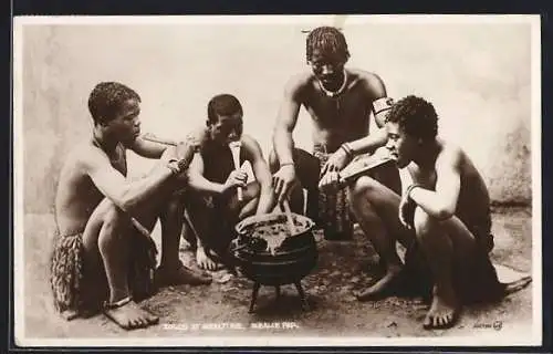 AK Zulus at Mealtime, afrikanische junge Männer essen aus einem Topf heraus