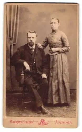 Fotografie Mauritz Edlund, Arboga, Hamngatan, Porträt eines sitzenden Mannes und einer stehenden Frau