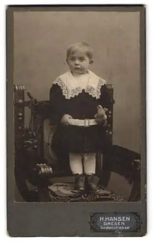 Fotografie H. Hansen, Gnesen, Lindenstrasse, Porträt eines Kindes auf einem Stuhl