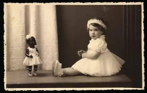 Fotografie Georges, Bruxelles, kleines niedliches Mädchen mit Josephien Baker Puppe im weissen Kleid, 1937