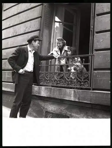 Fotografie US-amerikanischer Schauspieler Eddie Constantine grüsst Frau und Kind am Fenster mit Hund