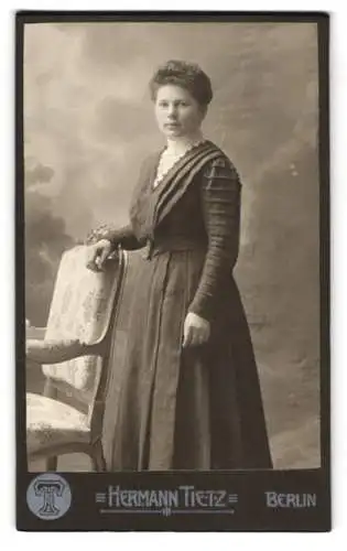 Fotografie Hermann Tietz, Berlin, Leipziger Str., Elegante Dame in hochgeschlossenem Kleid