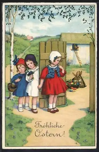 Künstler-AK Lia Döring: drei Mädchen beobachten Osterhasen am Eiernest, Herzlichen Ostergruss
