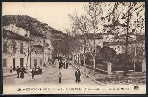 AK La Trinité-Victor, Rue de la Mairie avec passants et vue sur les collines