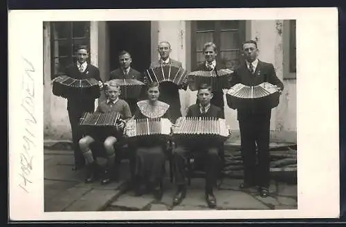 Foto-AK Gruppe von Akkordeonspielern vor dem Haus