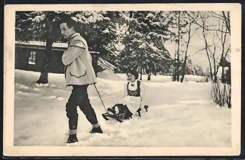 AK Mann zieht Frau auf Schlitten im Winter