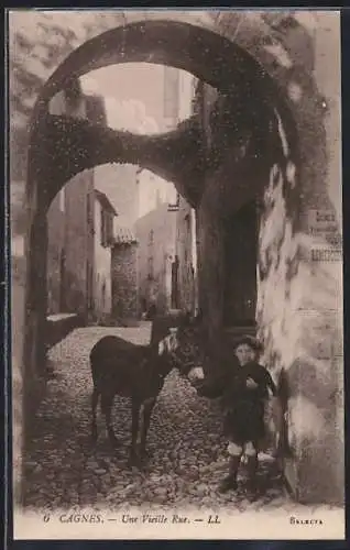 AK Cagnes, Une Vieille Rue avec un enfant et un âne sous un arc en pierre