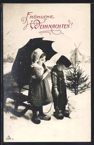 AK Holländisches Kinderpaar mit Schlitten im Schnee, Im Hintergrund Windmühle, Weihnachtsgruss