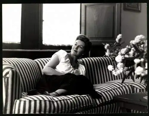 Fotografie Hecht, Berlin, Portrait Opernsängerin Nelly Corradi im Wohnzimmer auf der Couch