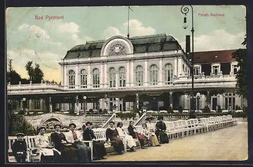 AK Bad Pyrmont, Fürstl. Kurhaus mit Kurgästen auf Ruhebänken