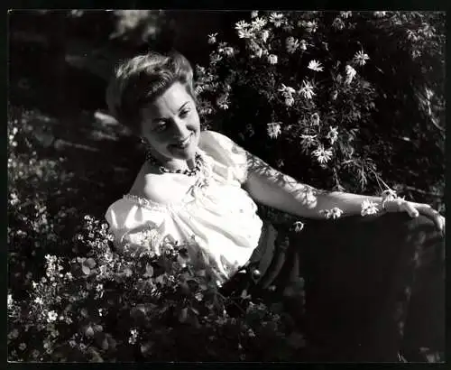 Fotografie Opernsängerin Nelly Corradi posiert zwischen Blumensträuchern