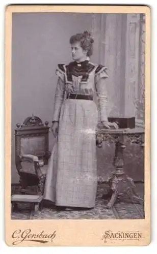 Fotografie C. Gersbach, Säckingen, Frau in elegantem Kleid neben Stuhl und Tisch