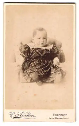 Fotografie C. Reichen, Burgdorf, bei der Flachsspinnerei, Porträt eines Kleinkindes in kariertem Kleid