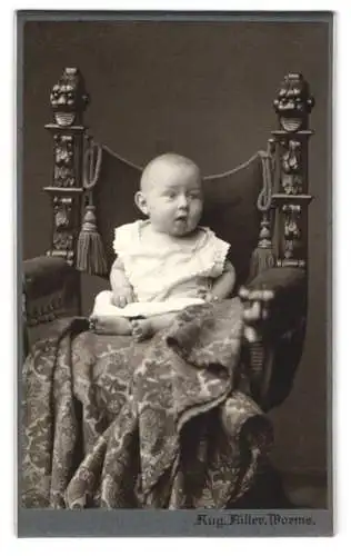 Fotografie Aug. Füller, Worms, Hardtgasse 1, Porträt eines Kleinkinds auf verziertem Stuhl