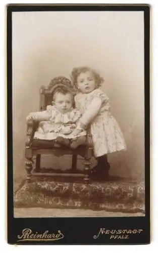 Fotografie Reinhard, Neustadt /Pfalz, Zwei Kinder auf kunstvollem Stuhl