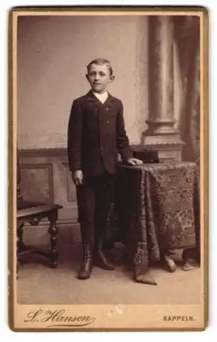 Fotografie L. Hansen, Kappeln, Junge im Anzug neben Tisch