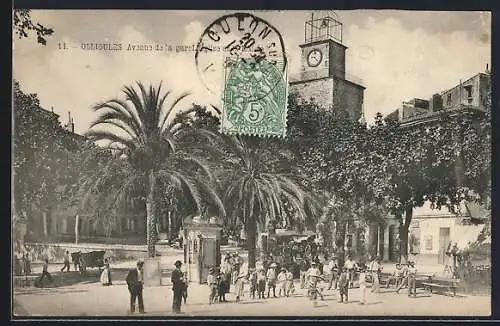 AK Ollioules, Avenue de la gare animée avec horloge et palmiers