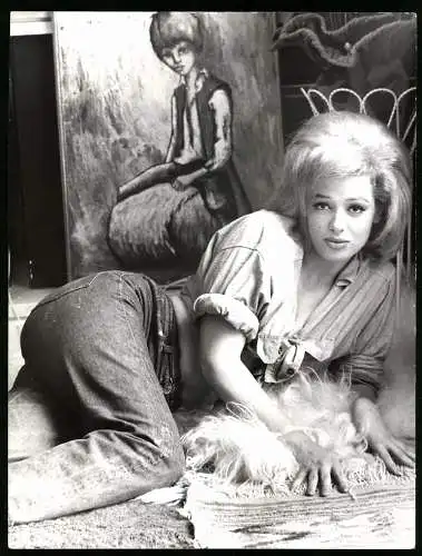Fotografie Herbert Fried, blondes Modell posiert in Jeanshose und Jeansbluse auf einem Fell