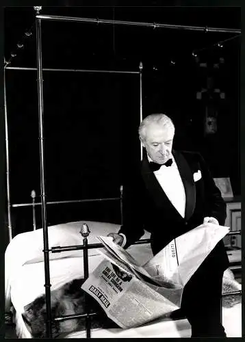 Fotografie Queen, London, Fotograf und Bühnenbildner Cecil Beaton im weinroten Jacket an seinem Bett liest Zeitung